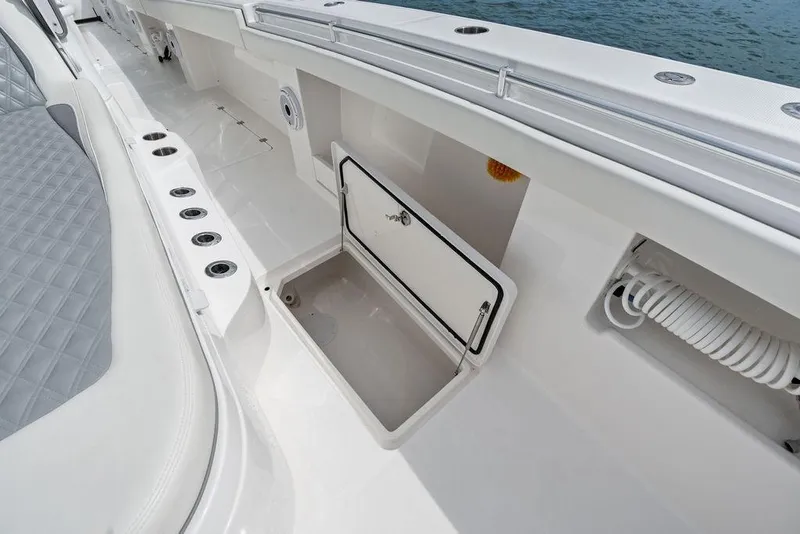 Slide: The Image of 2021 Invincible 46 Catamaran deck with storage compartment and seating area. - 29