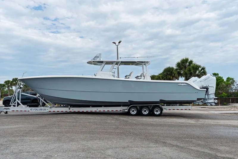 Slide: The Image of 2021 Invincible 46 Catamaran on trailer, parked outdoors under cloudy sky. - 57