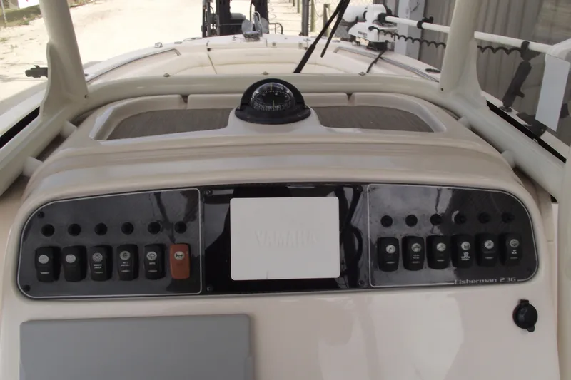 Slide: The Image of 2023 Grady-White Fisherman 236 dashboard with controls and compass. - 19