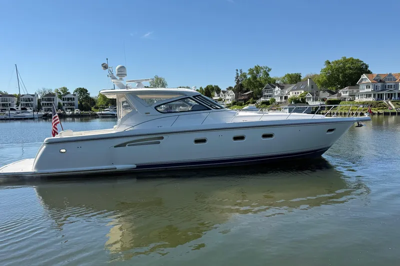 The Image of 2001 Tiara Yachts 5200 Express in serene waters, surrounded by waterfront homes. - 0