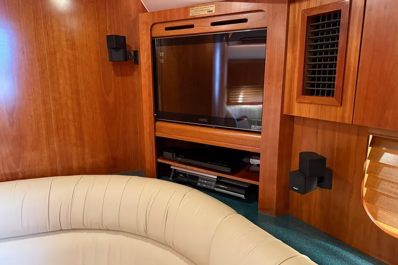 Slide: The Image of Interior of 2001 Tiara Yachts 5200 Express with TV and beige seating. - 22