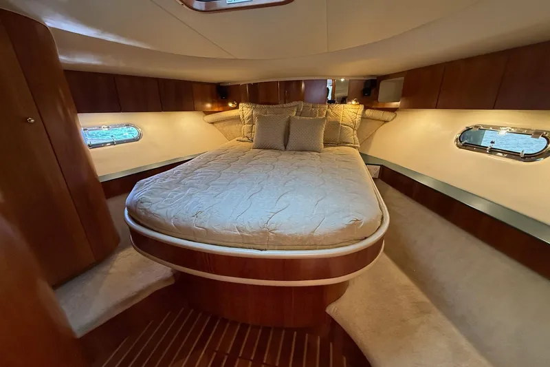 Slide: The Image of Luxurious cabin interior of 2001 Tiara Yachts 5200 Express with cozy bed and elegant wood finish. - 28