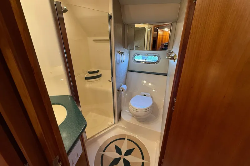 Slide: The Image of Bathroom interior of 2001 Tiara Yachts 5200 Express, featuring shower, toilet, and sink. - 29