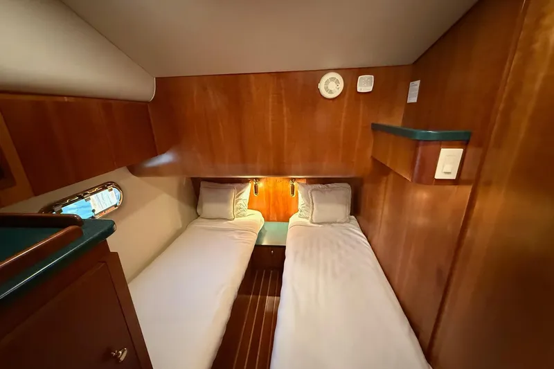 Slide: The Image of Cabin interior of 2001 Tiara Yachts 5200 Express with twin beds and wooden finish. - 33