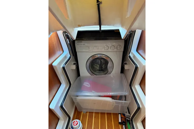Slide: The Image of Washing machine inside 2001 Tiara Yachts 5200 Express, with storage container and wooden flooring. - 34