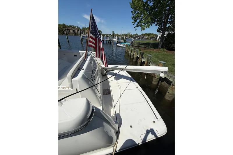 Slide: The Image of 2001 Tiara Yachts 5200 Express docked, featuring American flag and scenic waterfront view. - 39