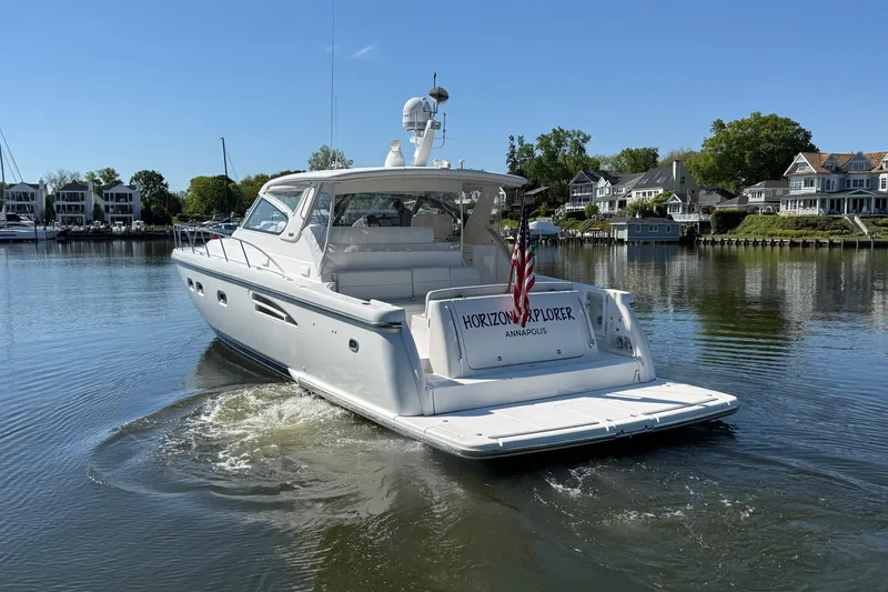 Slide: The Image of 2001 Tiara Yachts 5200 Express boat on calm water near residential shoreline. - 4