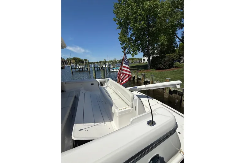 Slide: The Image of 2001 Tiara Yachts 5200 Express docked, featuring spacious deck and American flag. - 41