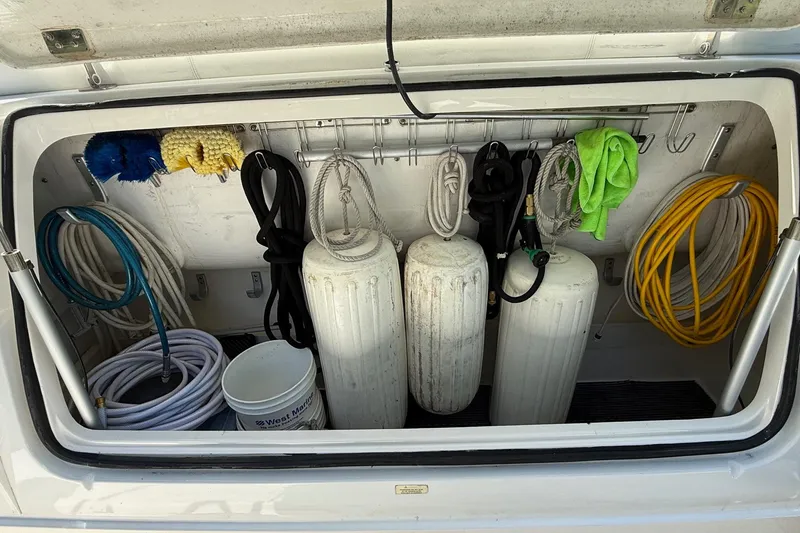 Slide: The Image of Storage compartment of a 2001 Tiara Yachts 5200 Express with ropes, fenders, and cleaning supplies. - 42