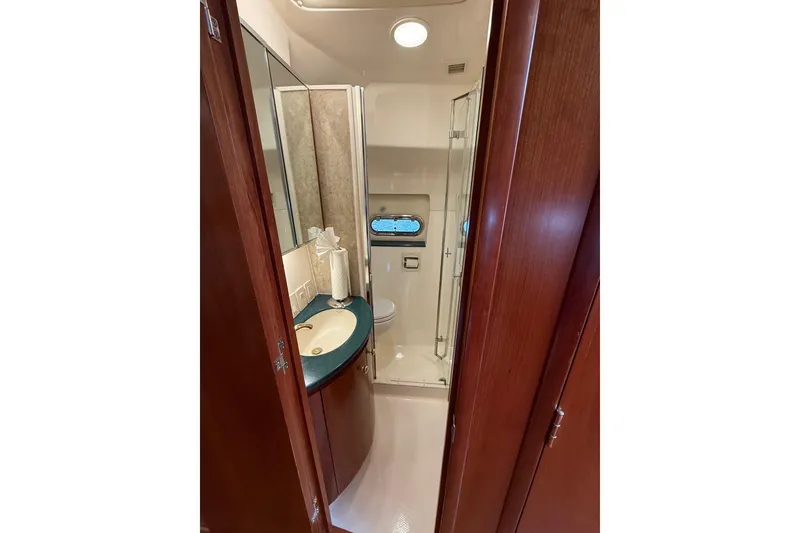 Slide: The Image of Luxurious bathroom in 2001 Tiara Yachts 5200 Express with wood accents and modern fixtures. - 46