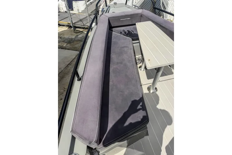 Slide: The Image of 2017 Axopar 28 T-Top boat interior with cushioned seating and table. - 10
