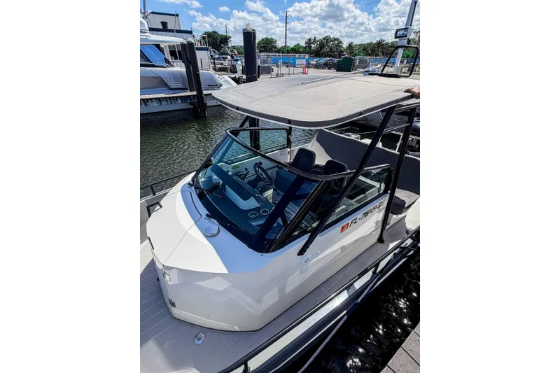 Slide: The Image of 2017 Axopar 28 T-Top boat docked at marina under sunny skies. - 12