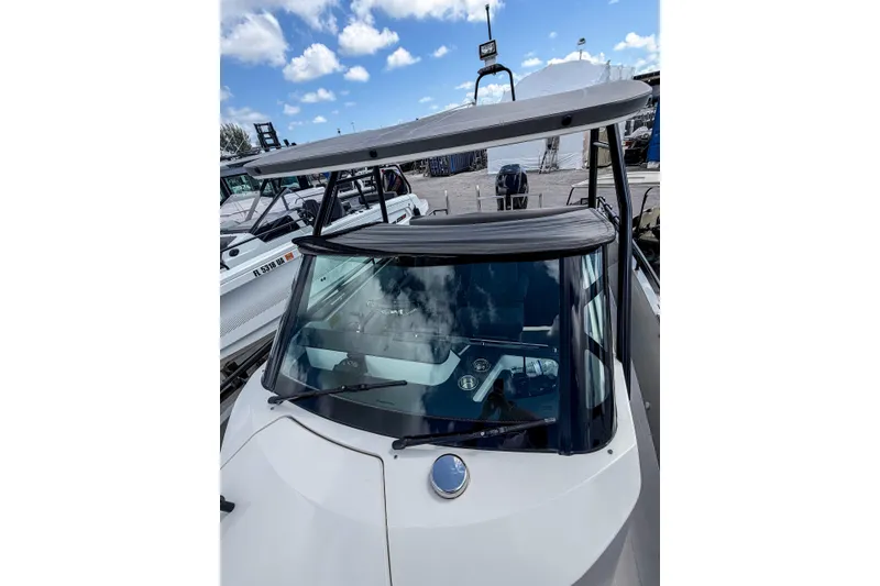 Slide: The Image of 2017 Axopar 28 T-Top boat with sleek design and modern features, docked under a blue sky. - 13