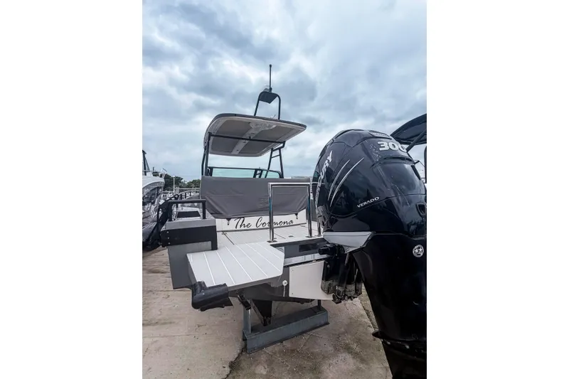 Slide: The Image of 2017 Axopar 28 T-Top boat with Mercury Verado engine, docked under cloudy skies. - 14