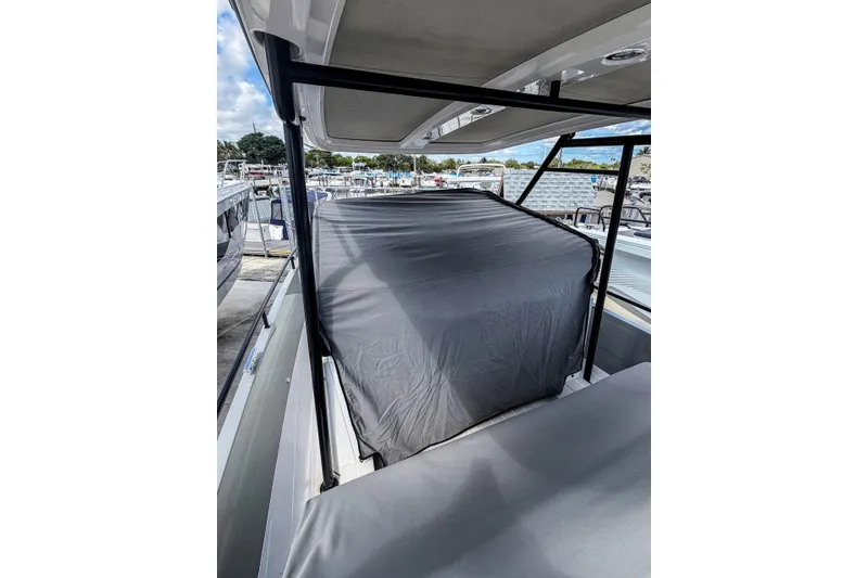 Slide: The Image of 2017 Axopar 28 T-Top boat with covered seating area at a marina. - 23