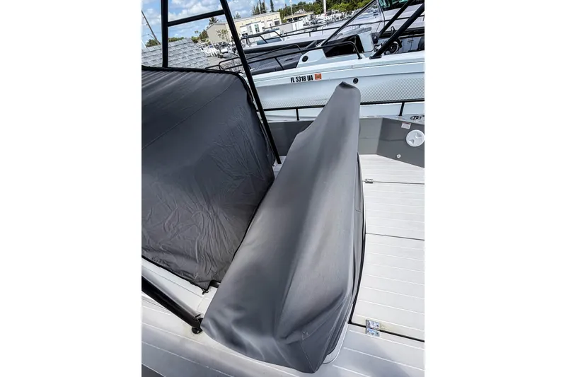 Slide: The Image of 2017 Axopar 28 T-Top boat with protective cover, docked in a marina. - 24