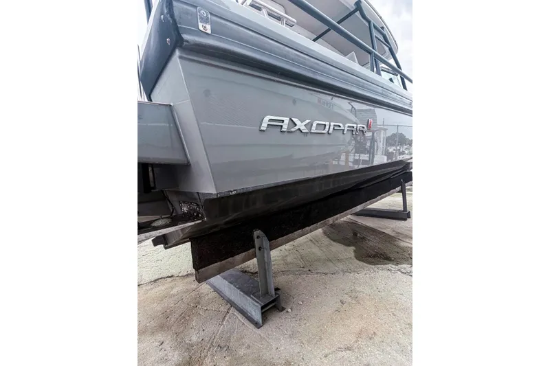 Slide: The Image of 2017 Axopar 28 T-Top boat on dry dock, showcasing sleek design and branding. - 28