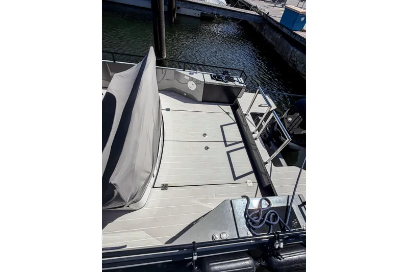 Slide: The Image of 2017 Axopar 28 T-Top boat deck with covered seating, docked by the water. - 5