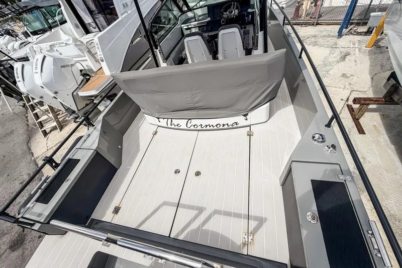 Slide: The Image of 2017 Axopar 28 T-Top boat interior with seating and helm, docked at marina. - 6
