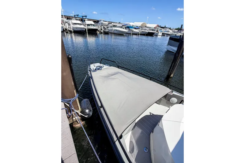 Slide: The Image of 2017 Axopar 28 T-Top boat docked at a marina under clear blue skies. - 9