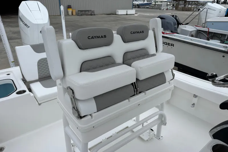 Slide: The Image of 2026 Caymas 26 HB boat seating with dual cushioned seats and backrests in a marina setting. - 11