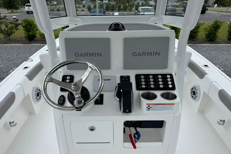 Slide: The Image of 2026 Caymas 26 HB boat helm with dual Garmin displays and steering wheel. - 12
