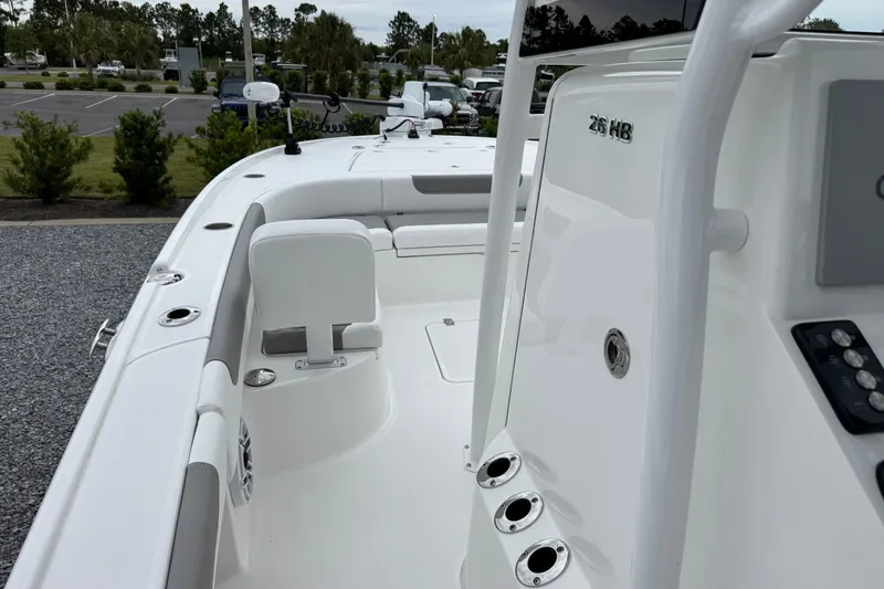 Slide: The Image of 2026 Caymas 26 HB boat interior with seating and control panel, parked outdoors. - 17