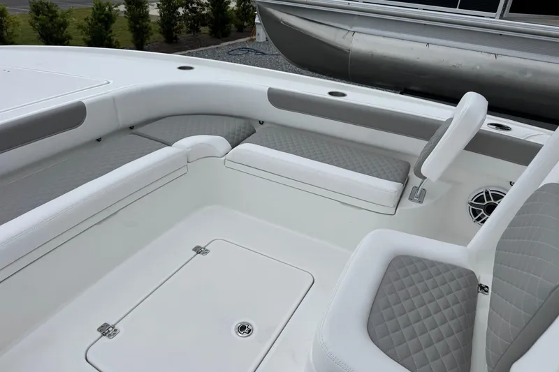 Slide: The Image of 2026 Caymas 26 HB boat interior with cushioned seating and storage compartment. - 19