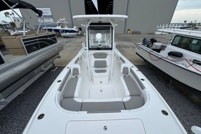 Slide: The Image of 2026 Caymas 26 HB boat with spacious seating, docked among other vessels. - 26