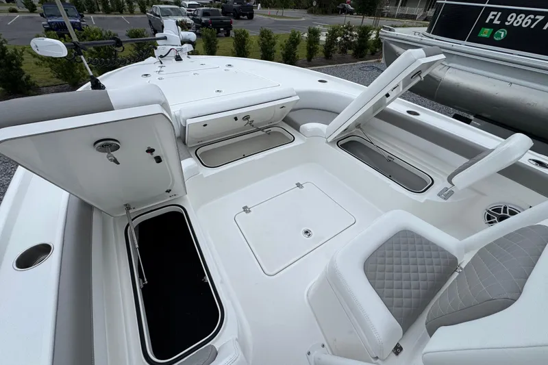 Slide: The Image of 2026 Caymas 26 HB boat interior with open storage compartments and seating. - 27