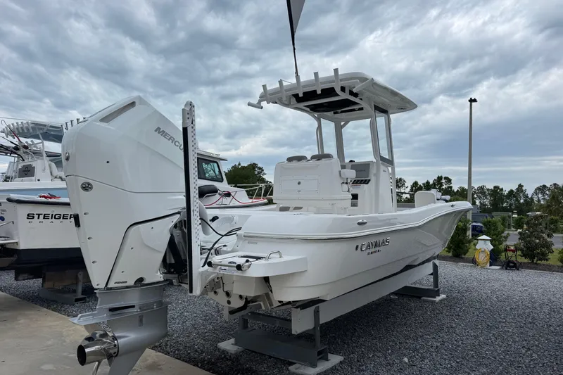 Slide: The Image of 2026 Caymas 26 HB boat with Mercury engine, displayed outdoors under cloudy skies. - 4