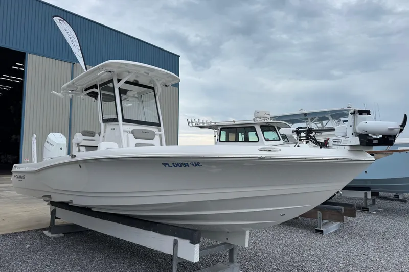 Slide: The Image of 2026 Caymas 26 HB boat displayed outdoors near a storage facility. - 5