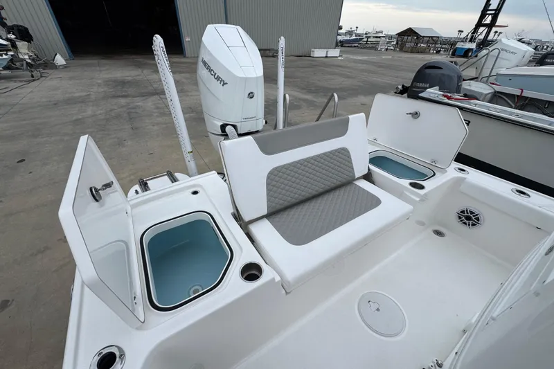 Slide: The Image of 2026 Caymas 26 HB boat interior with seating, storage compartments, and Mercury outboard motor. - 9