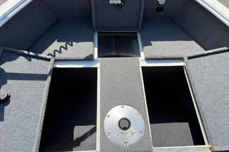 Slide: The Image of 2022 G3 Angler V164 C boat interior with storage compartments and carpeted flooring. - 11