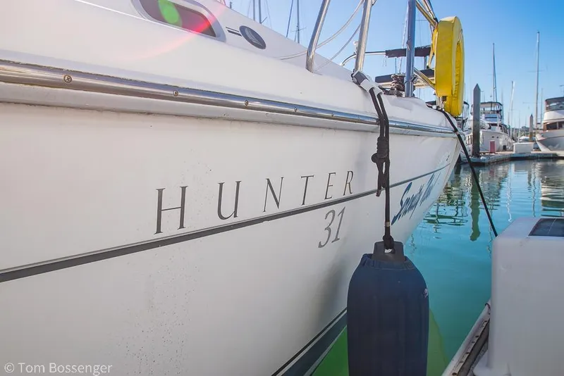 Slide: The Image of 2008 Hunter 31 sailboat docked in marina, side view with clear water reflection. - 4