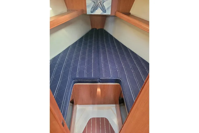 Slide: The Image of Interior cabin of 2008 Hunter 31 sailboat with blue patterned bedding. - 40