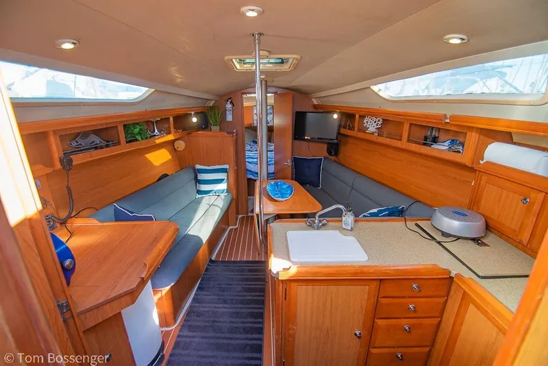 Slide: The Image of Interior of a 2008 Hunter 31 sailboat with cozy seating and wooden cabinetry. - 6