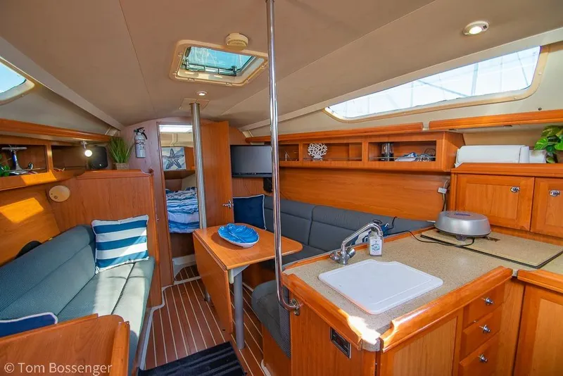 Slide: The Image of Interior of a 2008 Hunter 31 sailboat with cozy seating and wooden cabinetry. - 7