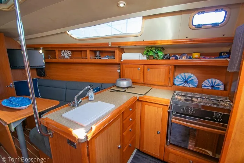 Slide: The Image of Interior of a 2008 Hunter 31 sailboat featuring a cozy kitchen and dining area. - 8