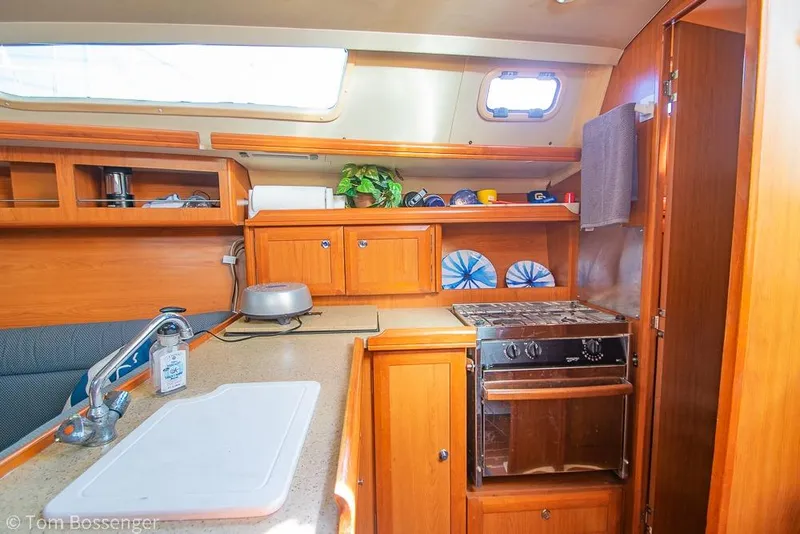 Slide: The Image of Interior of 2008 Hunter 31 sailboat kitchen with wooden cabinetry and stove. - 9