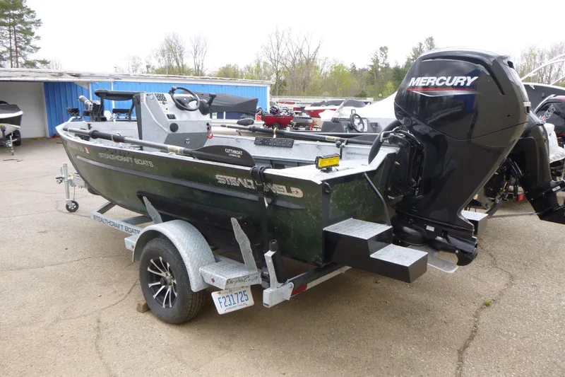 Slide: The Image of 2025 StealthCraft 16 StealthWeld boat with Mercury engine on trailer, parked outdoors. - 3