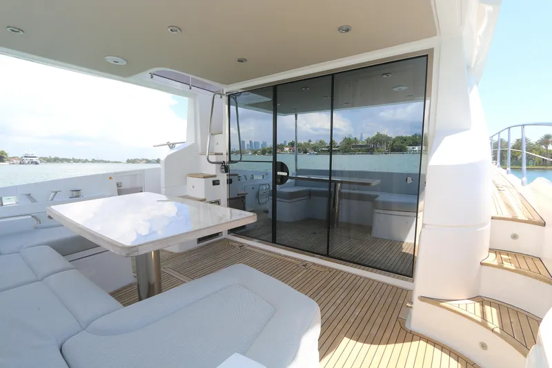 Slide: The Image of Luxurious 2020 Azimut 55 yacht deck with seating, table, and scenic water view. - 15