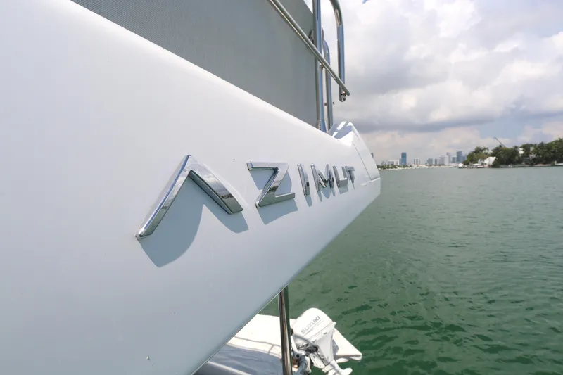 Slide: The Image of Azimut 55 yacht, 2020 model, cruising on a serene waterway under a cloudy sky. - 30