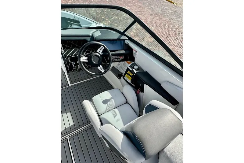 Slide: The Image of 2018 Nautique Super Air Nautique GS22 cockpit with steering wheel and seating. - 34
