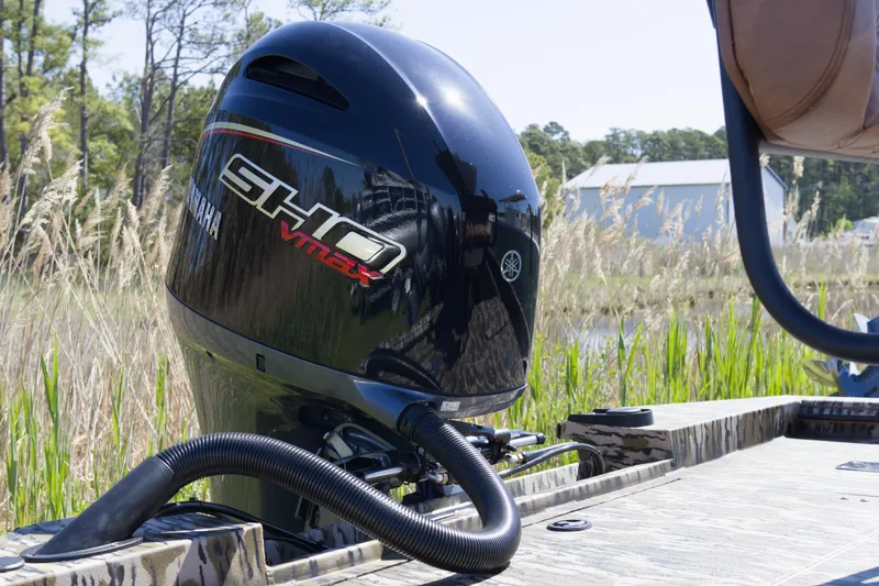 Slide: The Image of Outboard motor on Avid 22 Recon boat, 2026 model, in a grassy outdoor setting. - 10