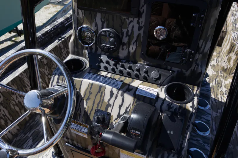 Slide: The Image of Control panel of 2026 Avid 22 Recon boat with camouflage design and steering wheel. - 13