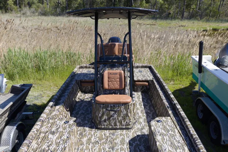 Slide: The Image of Camouflage-patterned 2026 Avid 22 Recon boat with tan seating, parked in a grassy area. - 14