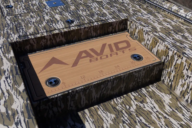 Slide: The Image of Camouflage-patterned Avid 22 Recon boat deck with branded wooden panel, 2026 model. - 16