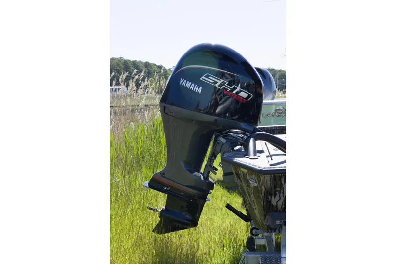 Slide: The Image of Outboard motor on Avid 22 Recon boat, 2026 model, in grassy landscape. - 5