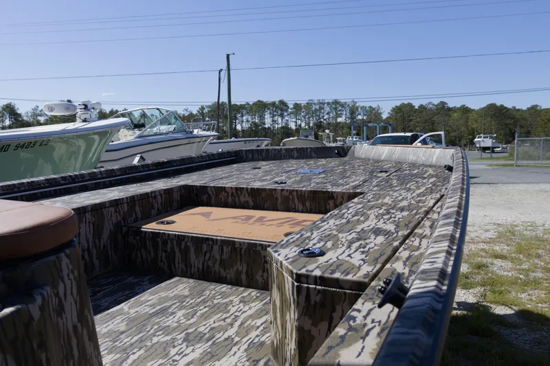 Slide: The Image of 2026 Avid 22 Recon boat with camouflage design, parked outdoors under clear sky. - 7